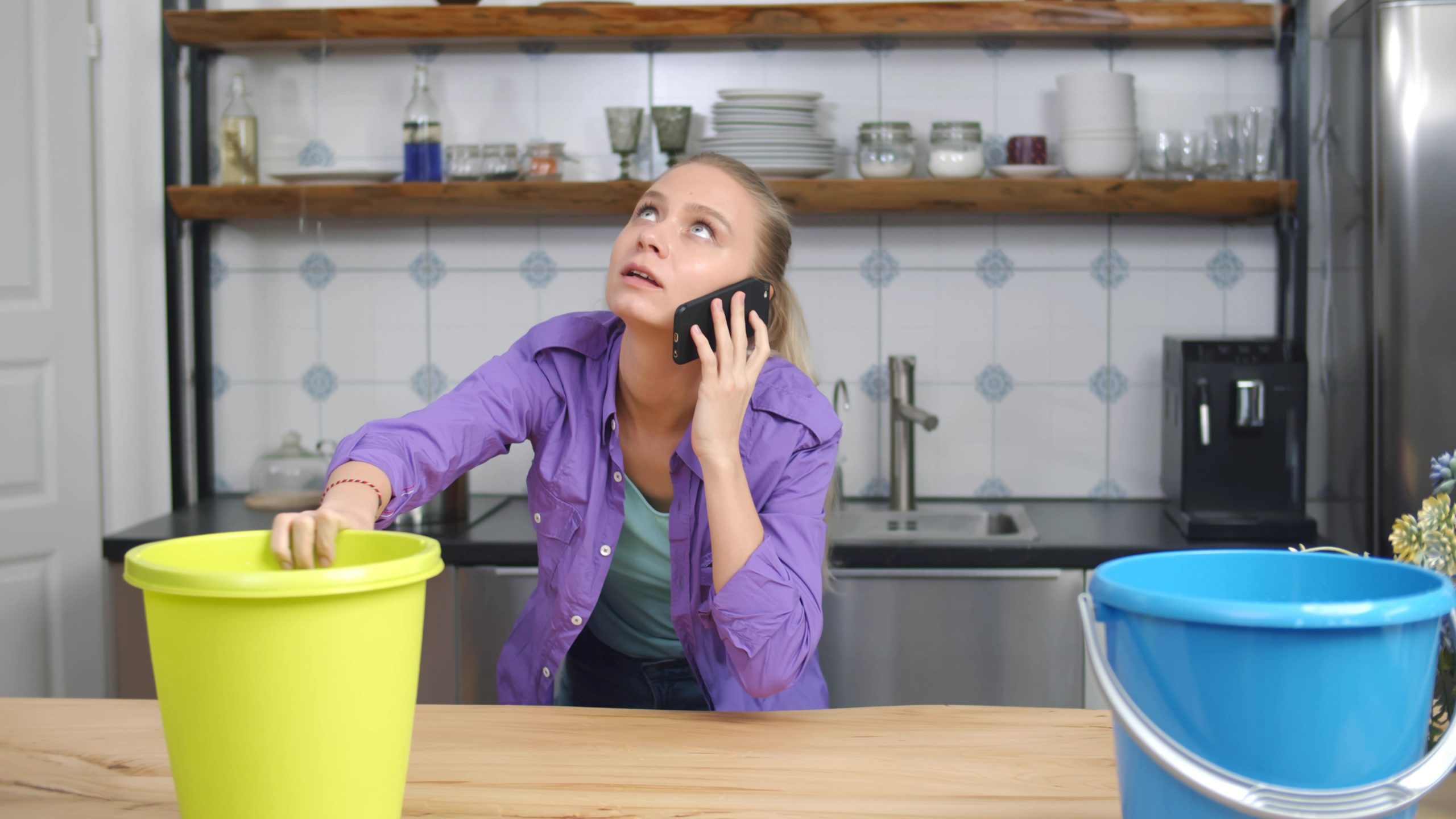 Homeowner calling for emergency plumbing repair during a leak