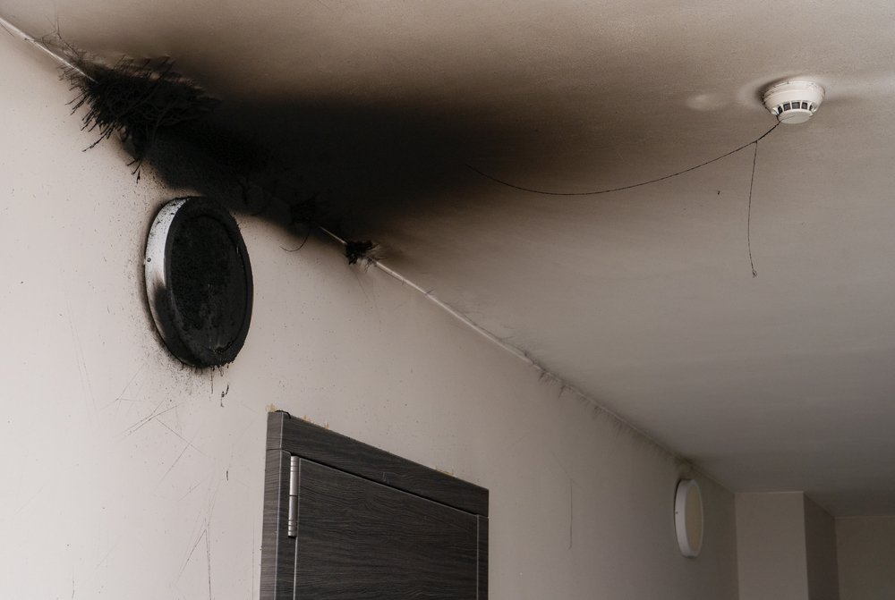 Burnt out light fixture showing fire damage on wall